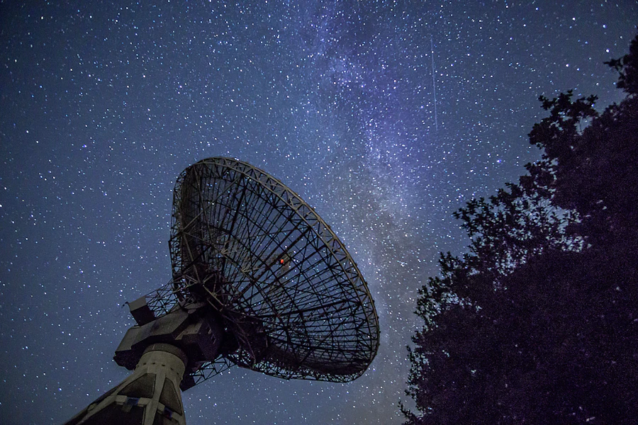 Radar and surveillance dish at night