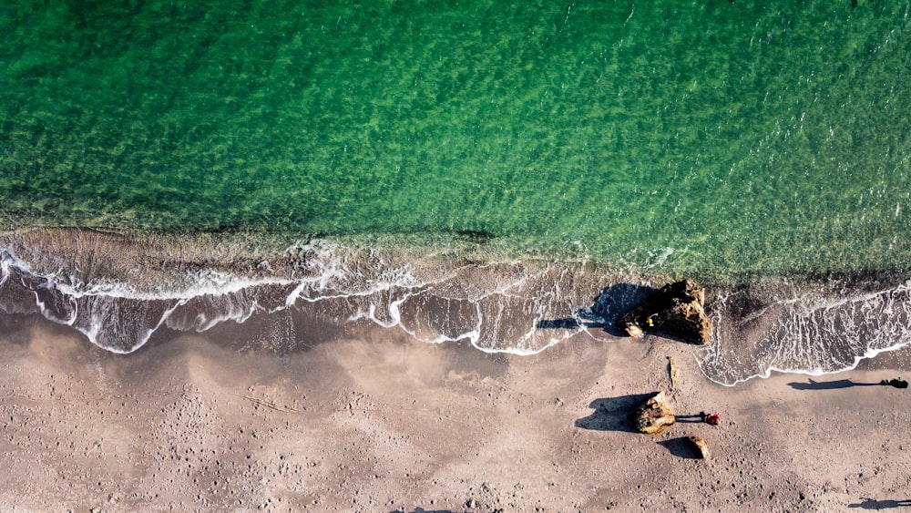 aerial view of sea waves crashing on shore during daytime