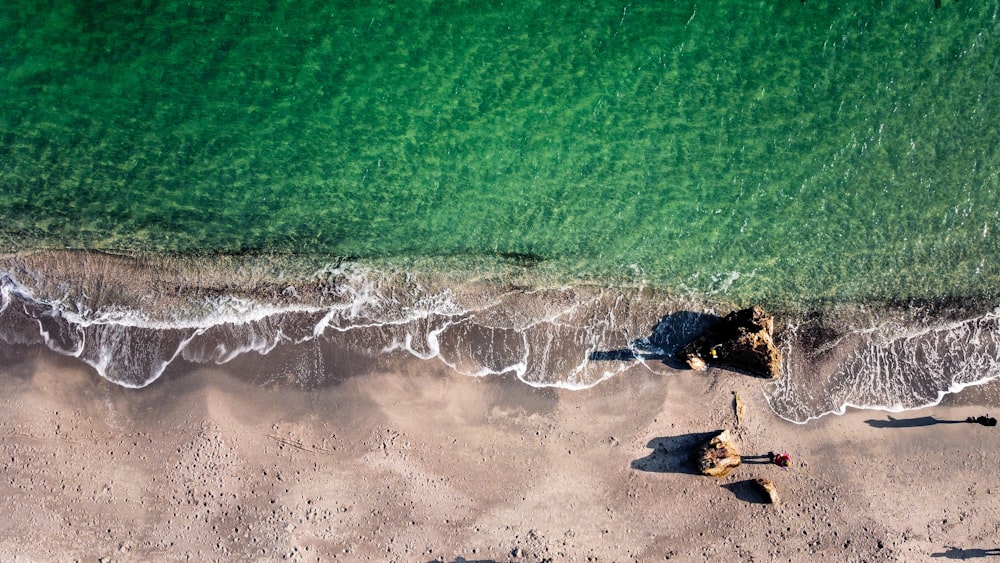 昼間に海岸に打ち寄せる波の空中写真