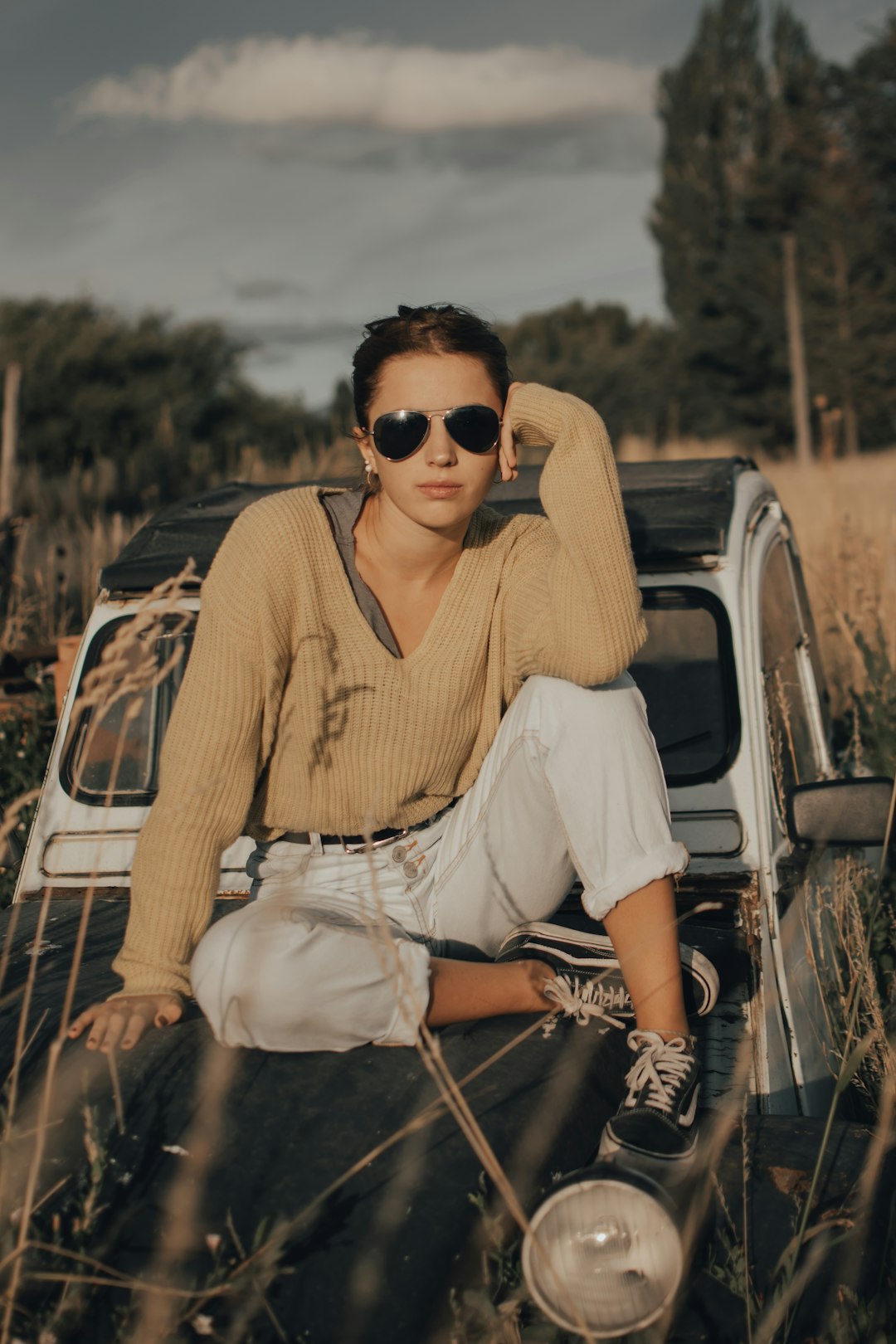 woman in yellow v neck shirt and white pants sitting on white car