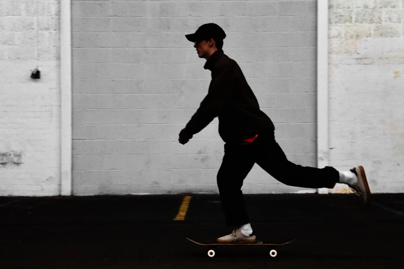 A skater in work pants mid-push