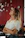 A smiling woman standing peacefully in her light-filled office with subtle spiritual decor.