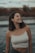 woman in white tank top standing near body of water during daytime