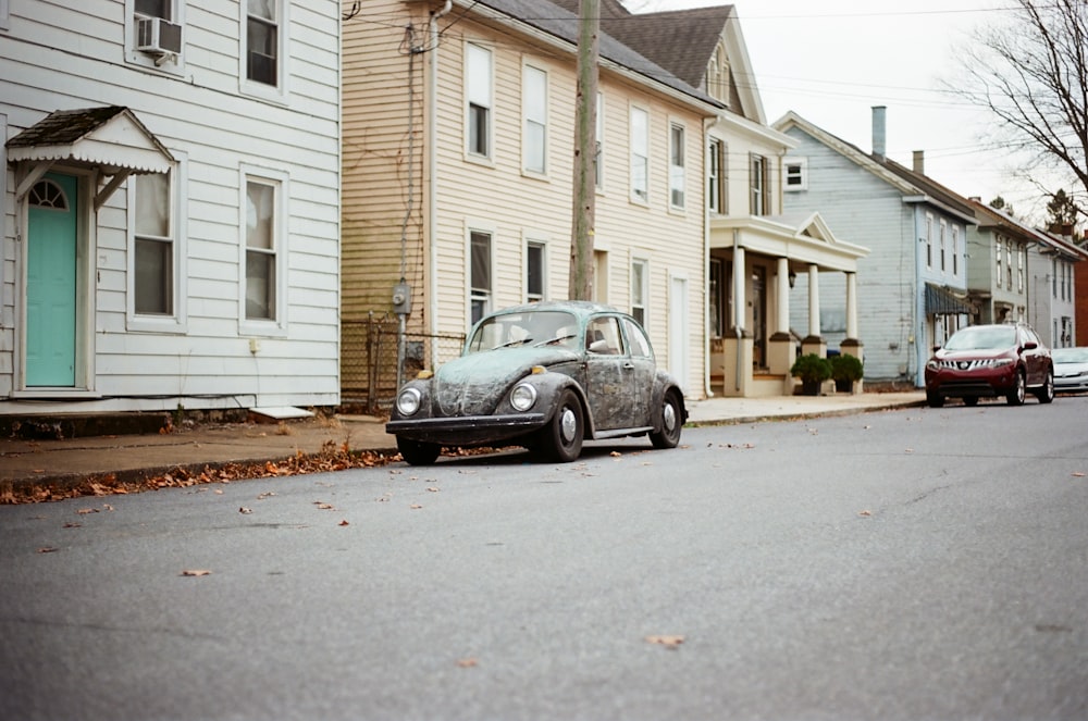 black sedan parked in front of white house