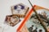 A collection of fantasy-themed items including a Harry Potter book with a detailed cover, a wand, a pair of round spectacles, and a decorative box labeled 'Frog'. These items are arranged on a white surface, showcasing a magical and whimsical theme.