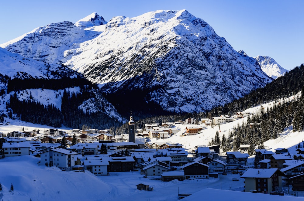 Casas blancas y marrones cerca de la montaña cubiertas de nieve durante el día