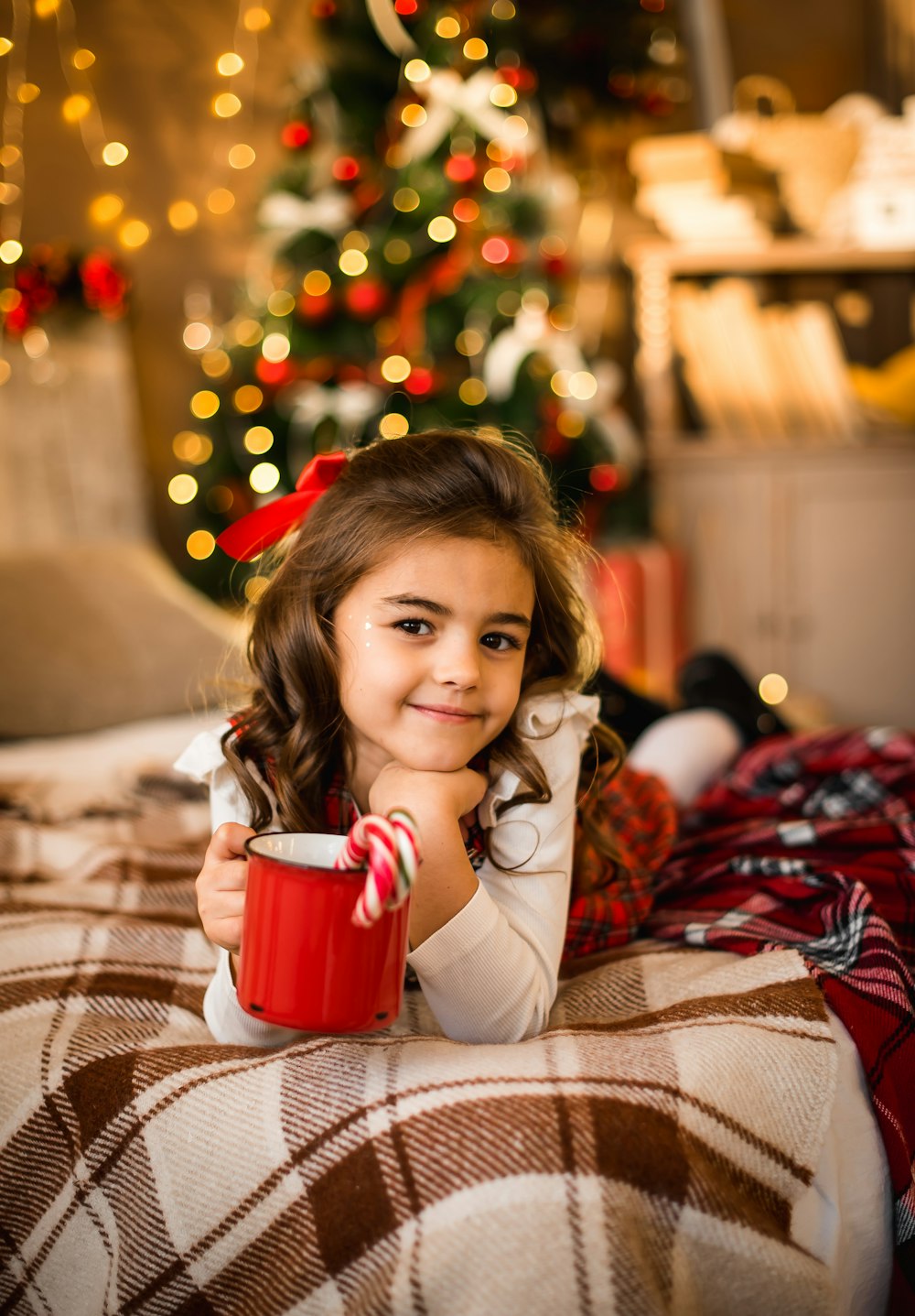 girl in white sweater holding red ceramic mug