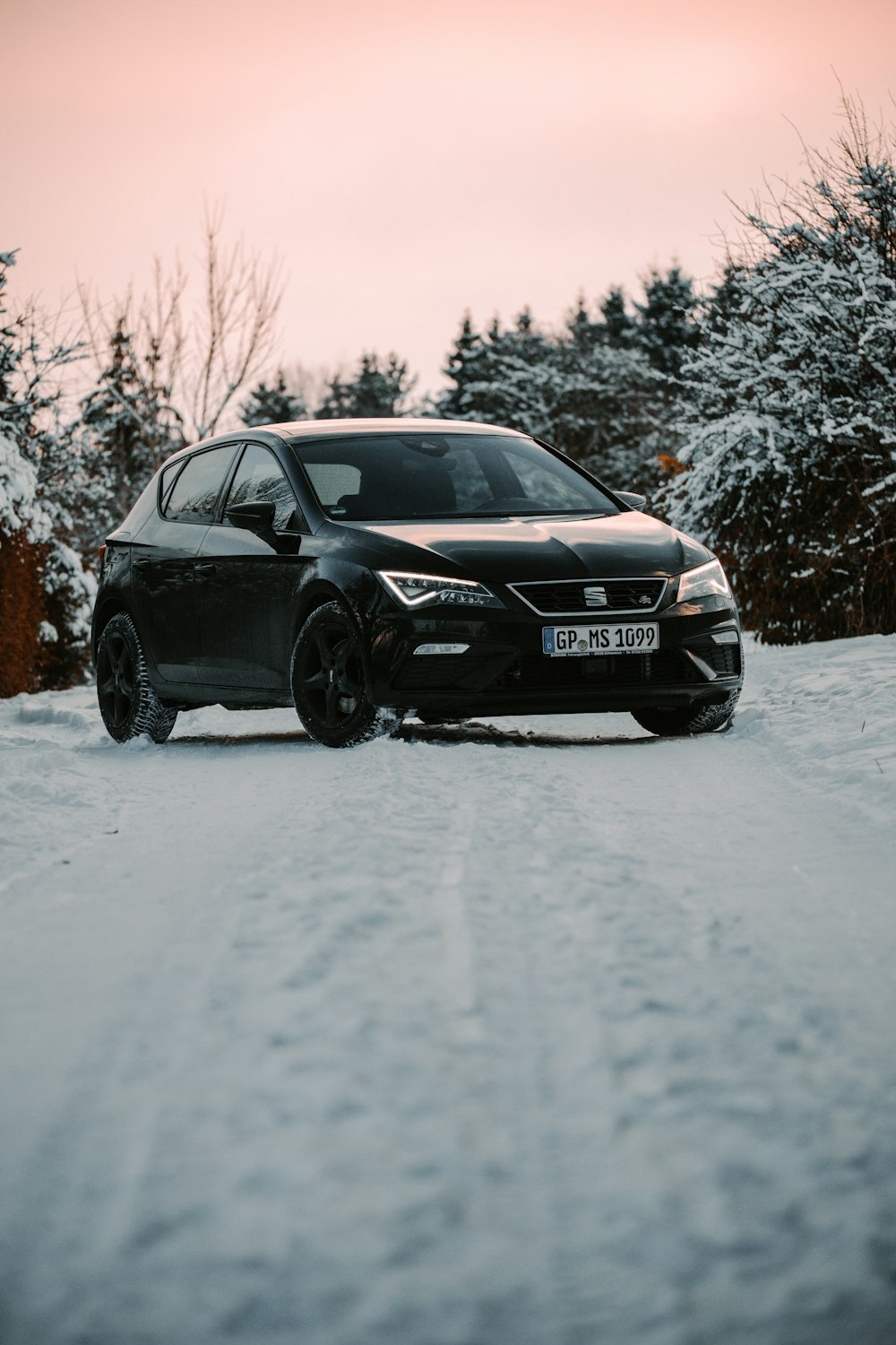 Audi sedán negro en carretera cubierta de nieve durante el día