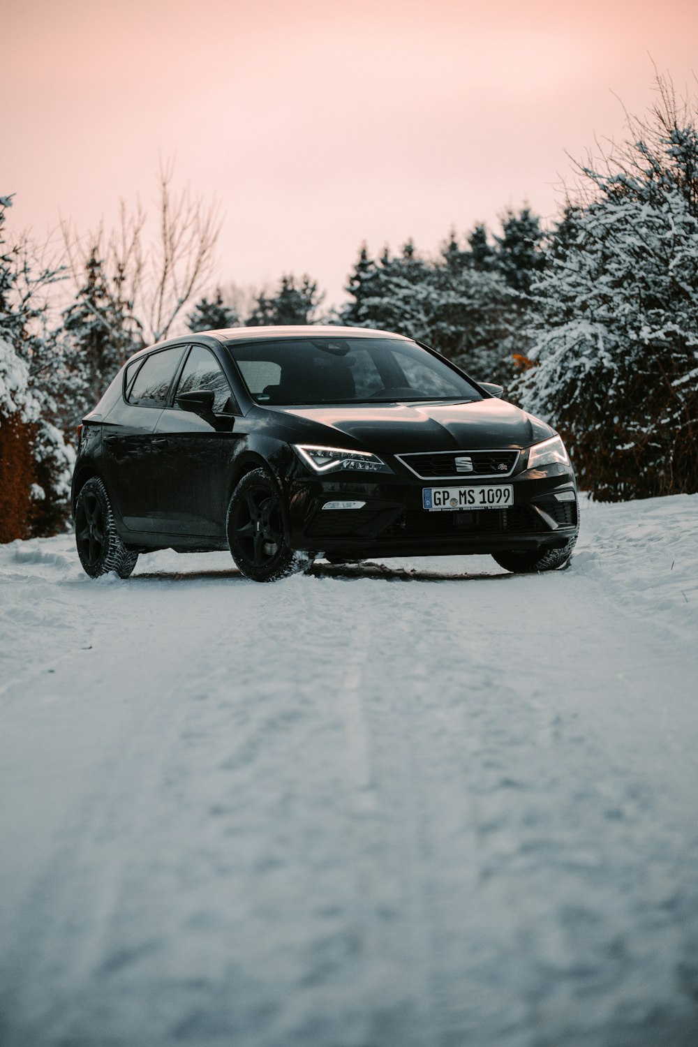 black audi sedan on snow covered road during daytime