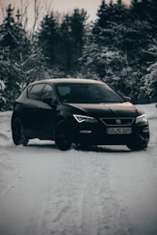 A sleek taxi car waiting at a snowy Austrian mountain roadside at dusk.