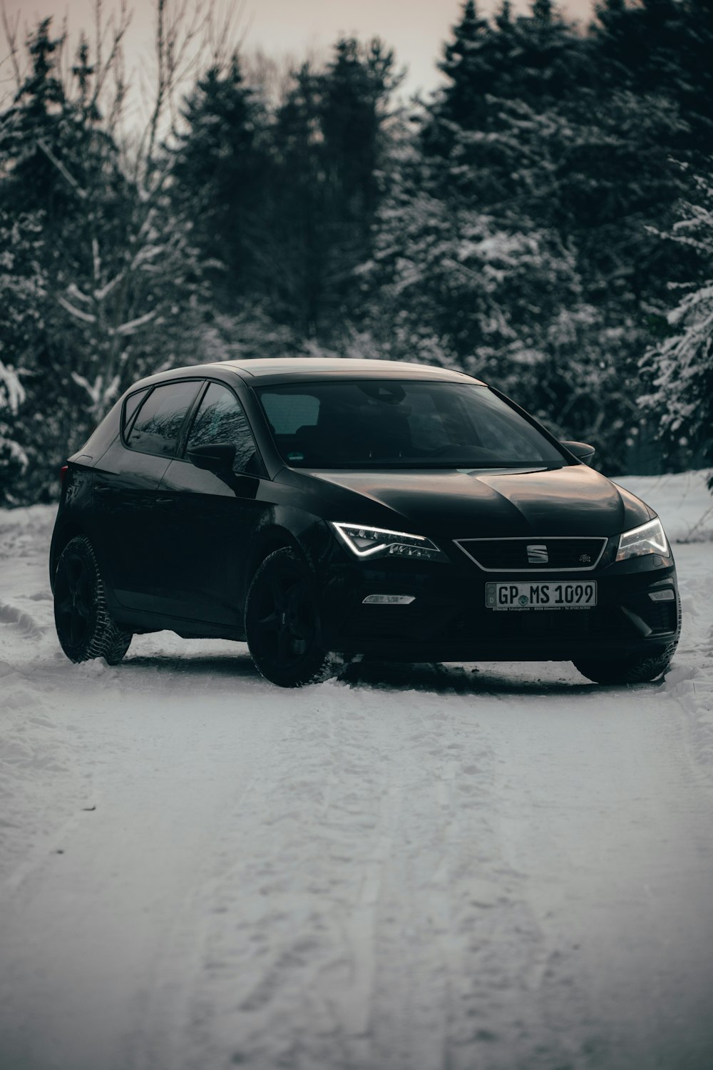 Audi R 8 negro en carretera cubierta de nieve