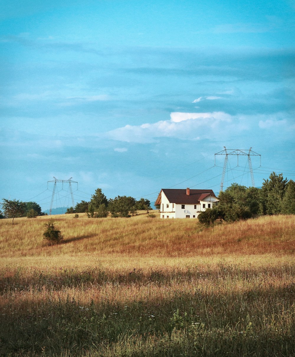 Casa bianca e rossa sul campo di erba verde sotto il cielo blu durante il giorno