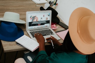 A friendly coach sitting at a desk with a laptop, reviewing a resume and interview notes.