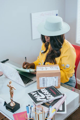 A candid photo of the author working at a cozy desk filled with Florida retirement guides and notes.