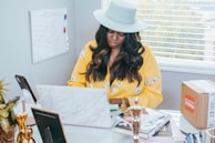 a woman sitting at a desk working on a laptop