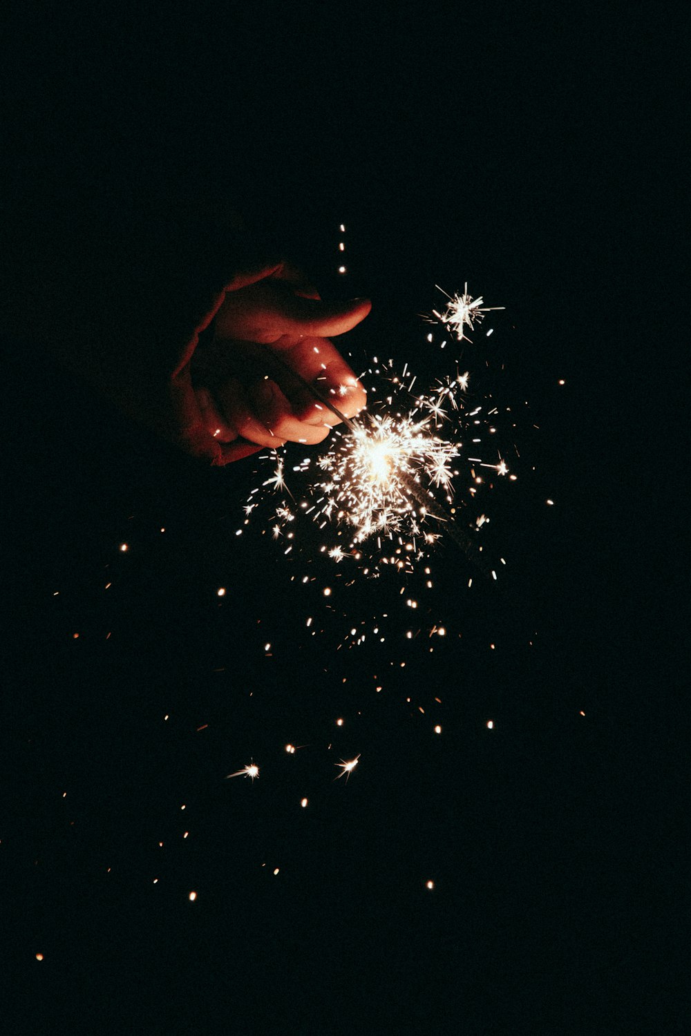 person holding white fireworks during night time