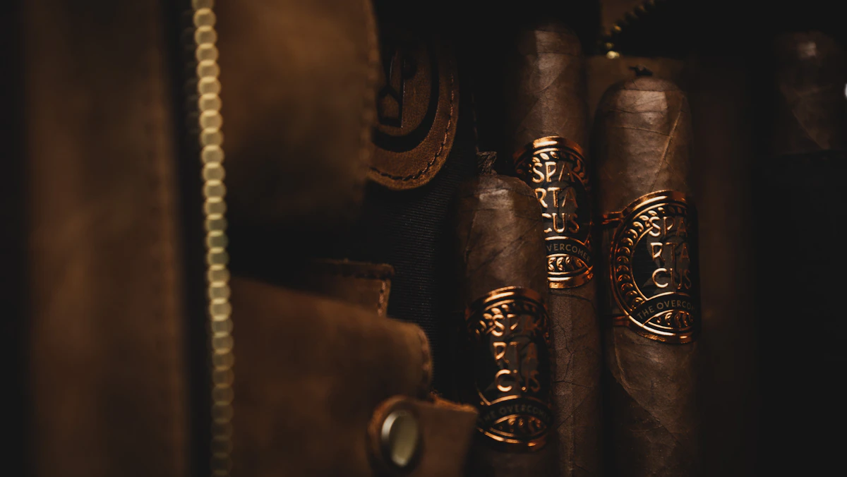 Hand-rolled cigars laid out on a dark workshop surface