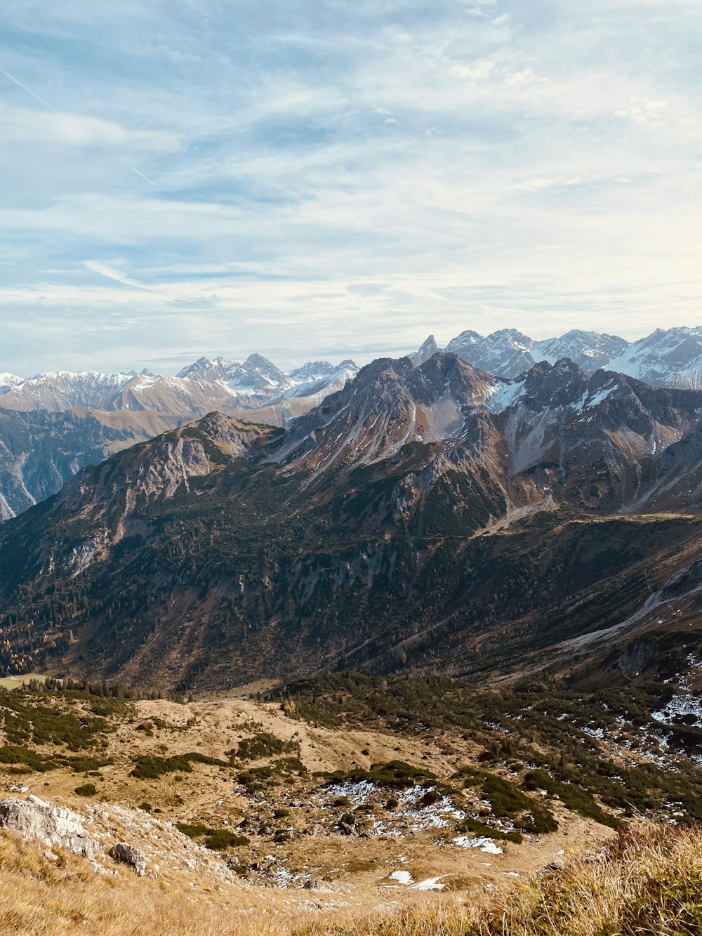 brown and gray mountains under white clouds and blue sky during daytime