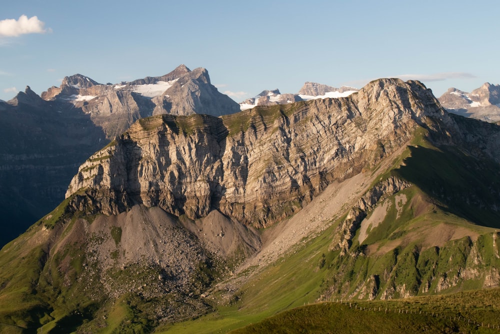 montagnes brunes et vertes sous ciel bleu pendant la journée