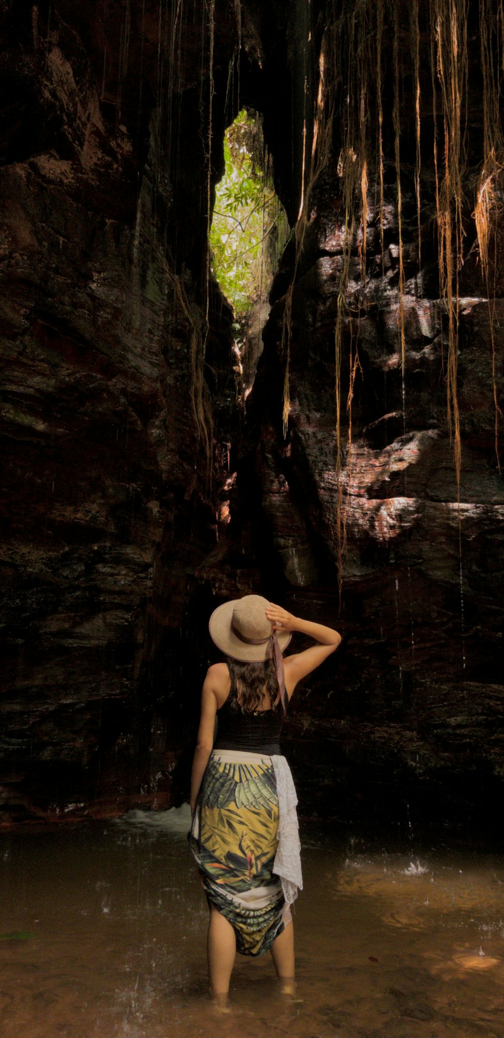 mulher de topless em shorts pretos sentados na rocha