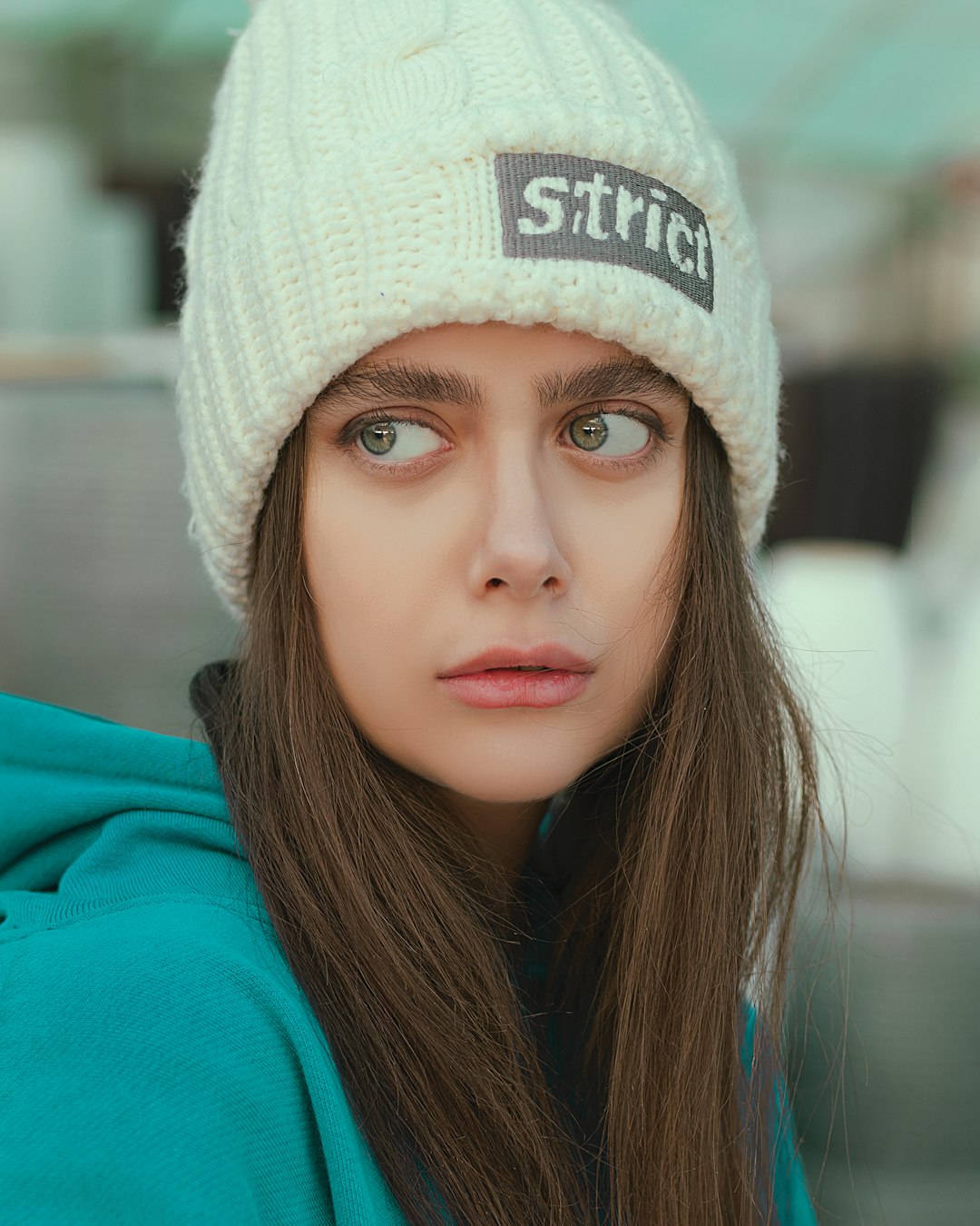 woman in white knit cap and teal hoodie