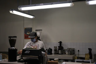 A technician refilling and maintaining a capsule vending machine in a cozy café.