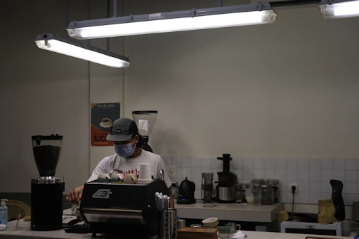 A technician refilling and maintaining a capsule vending machine in a cozy café.