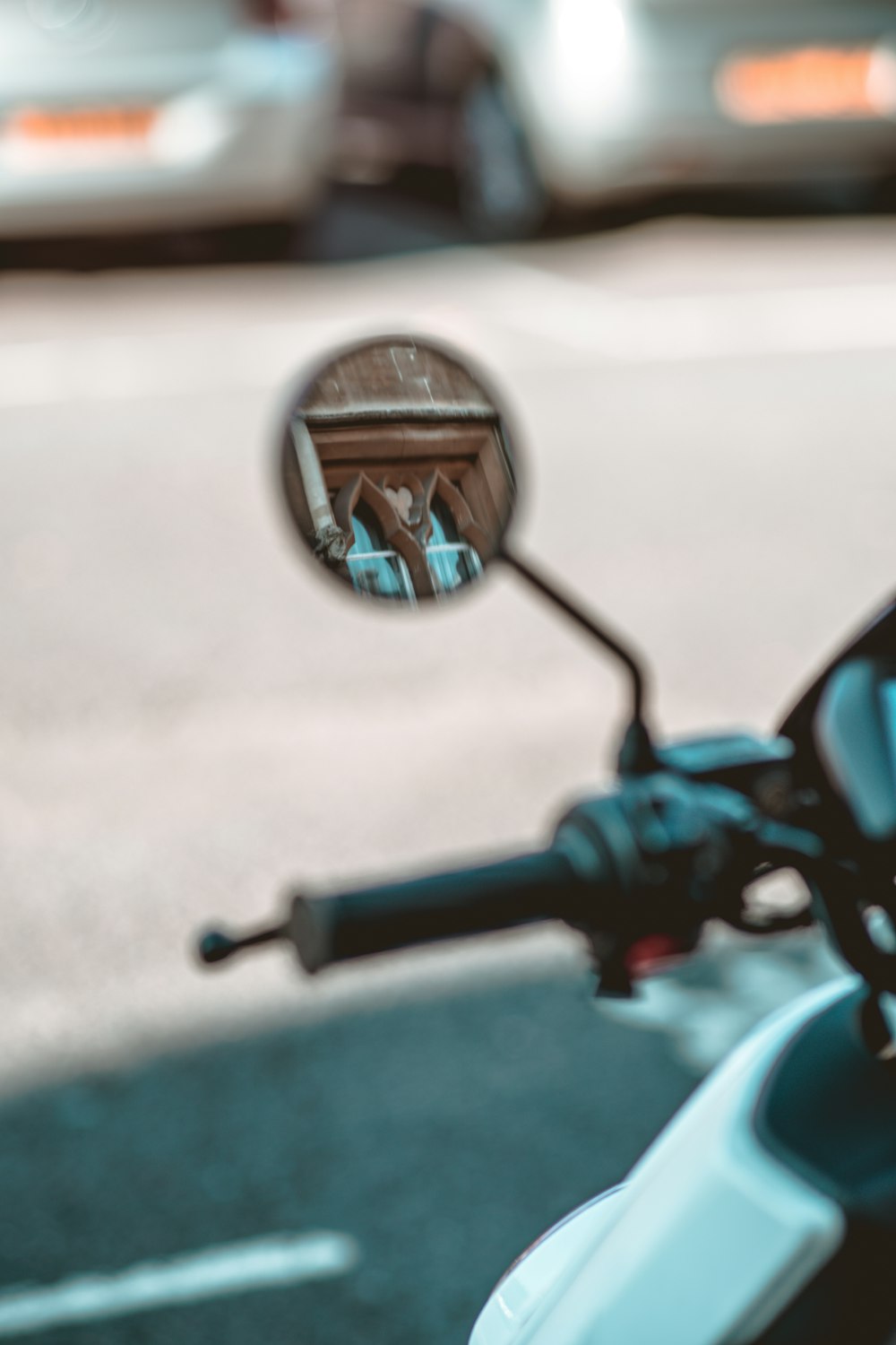 black motorcycle side mirror reflecting the road