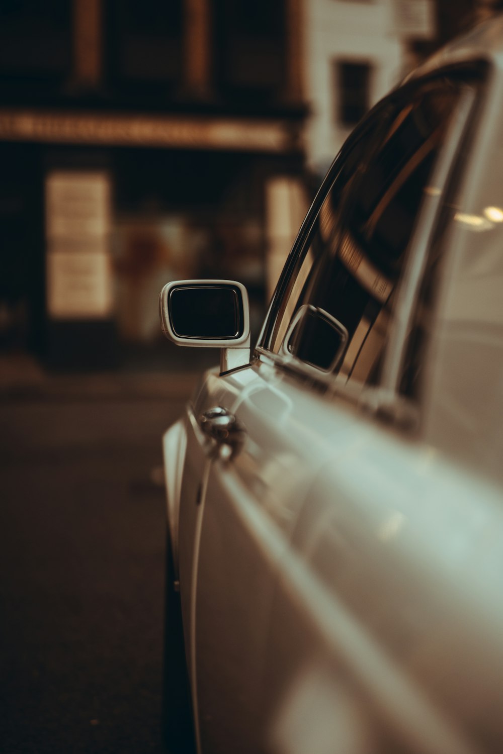 white car in front of brown building during night time