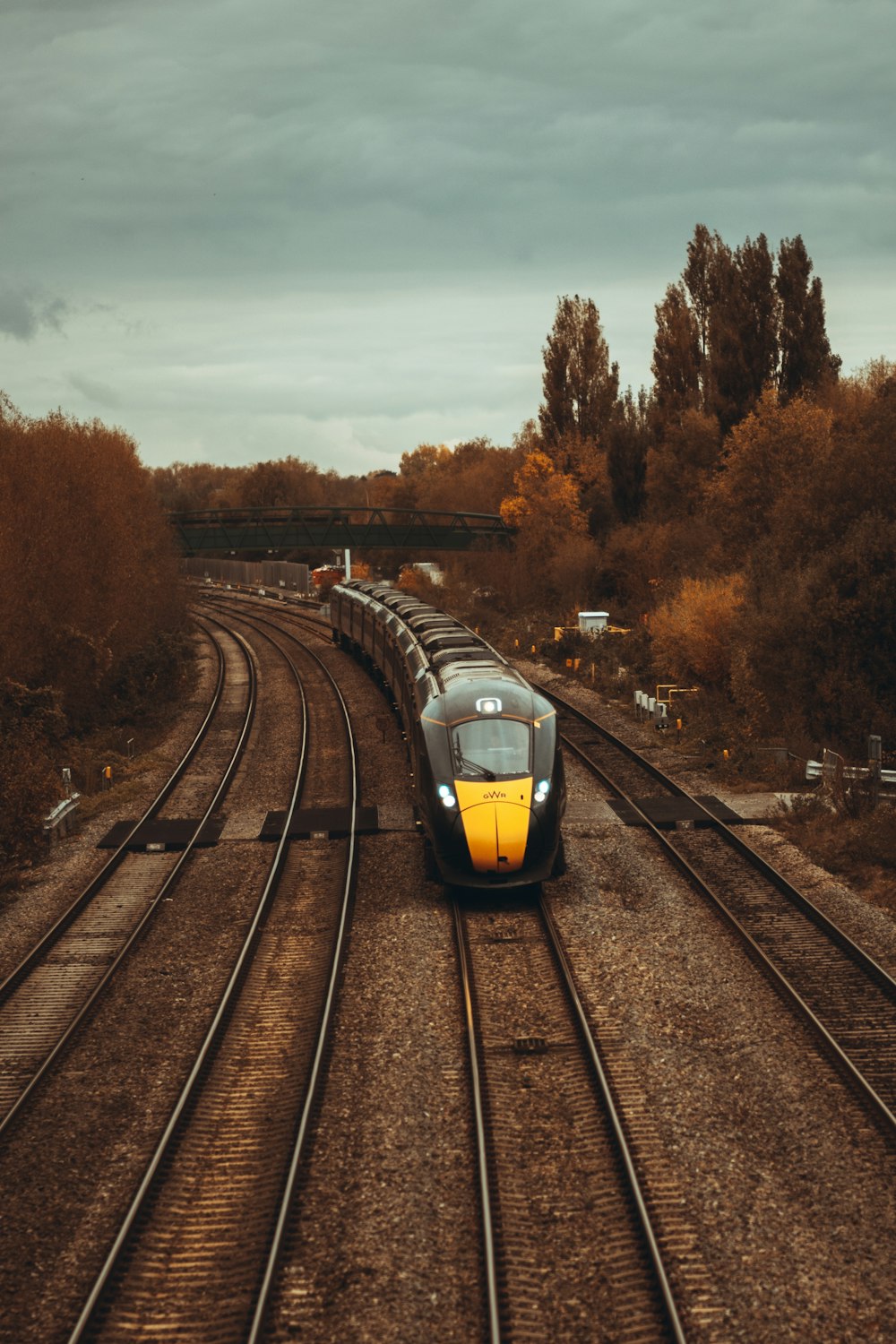 yellow and black train on rail tracks during daytime