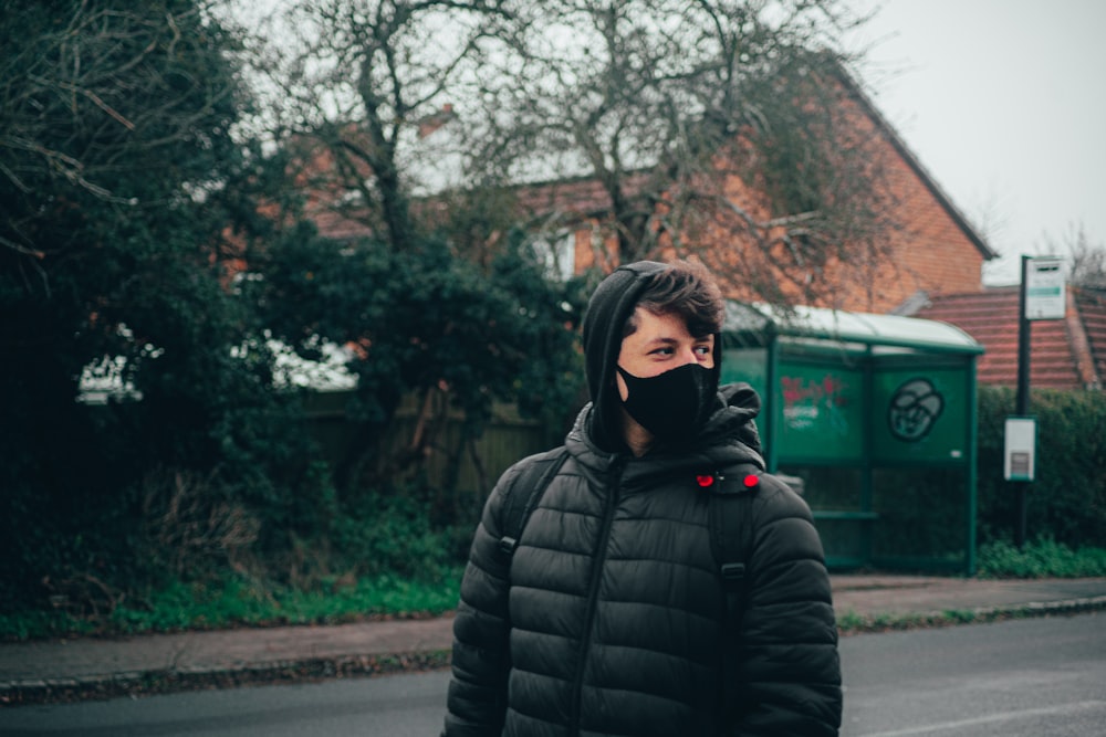 woman in black bubble jacket standing on road during daytime