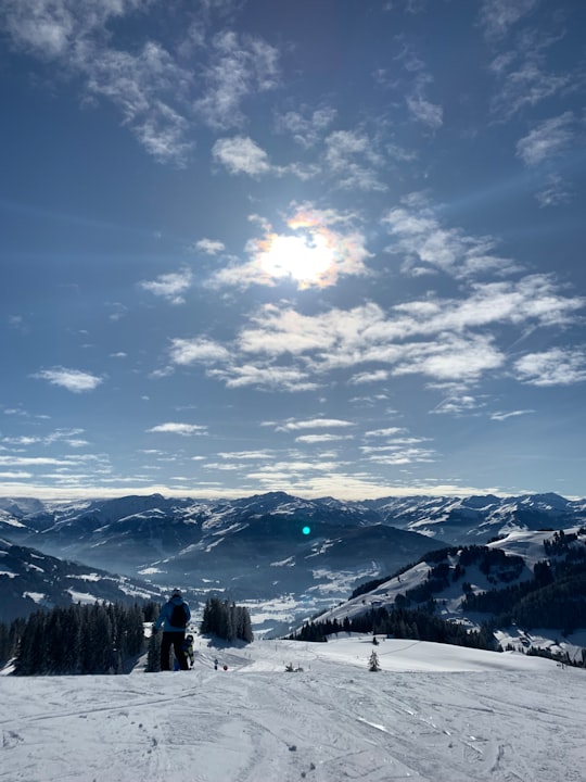 person standing on snow covered ground under blue sky and white clouds during daytime in Tyrol Austria