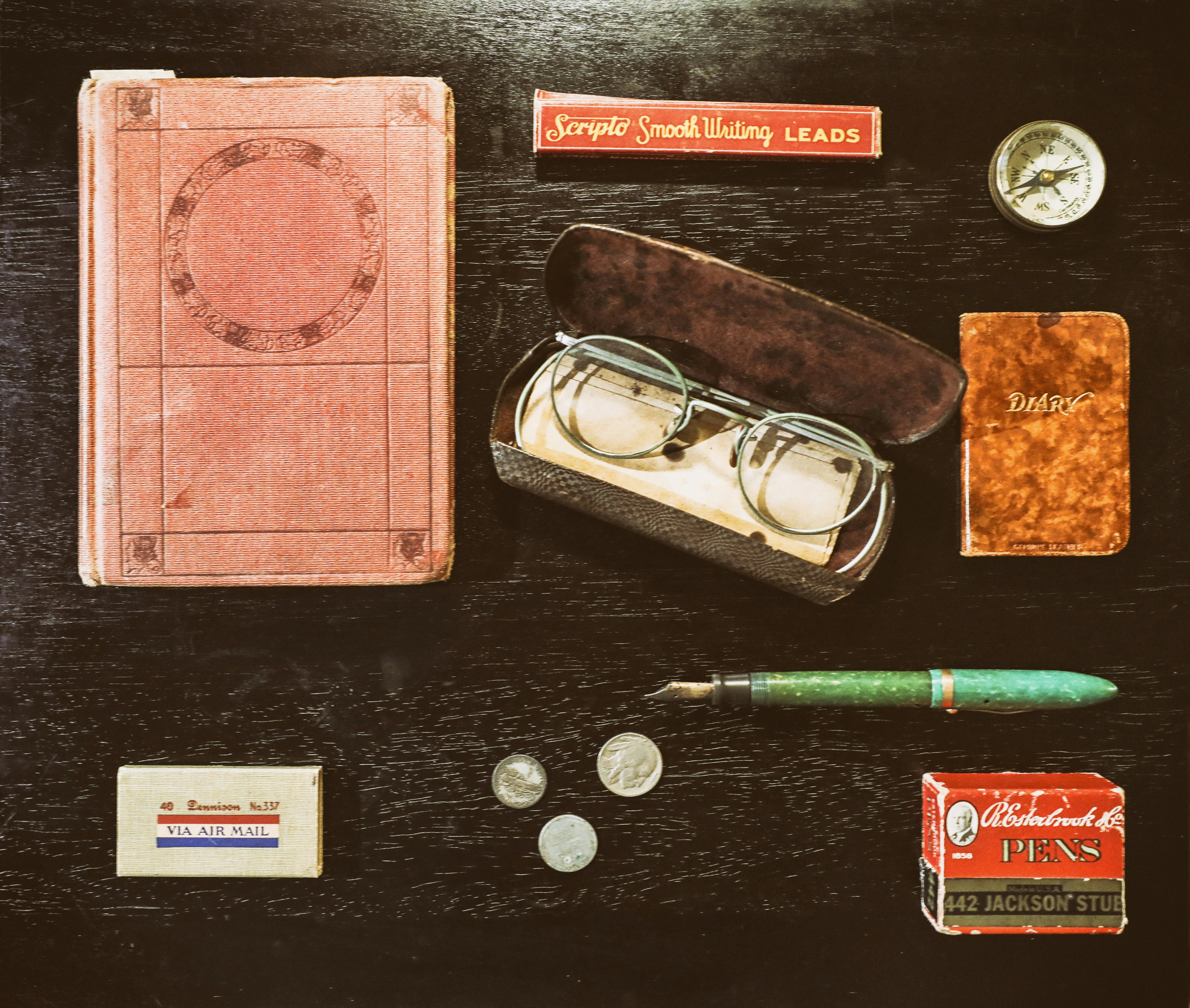 Various crafting materials and tools laid out for making realistic fake money, including paper, inks, and cutting tools