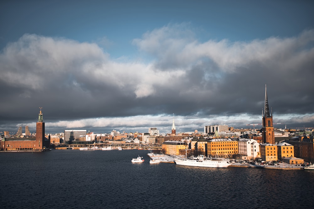 city skyline near body of water under cloudy sky during daytime