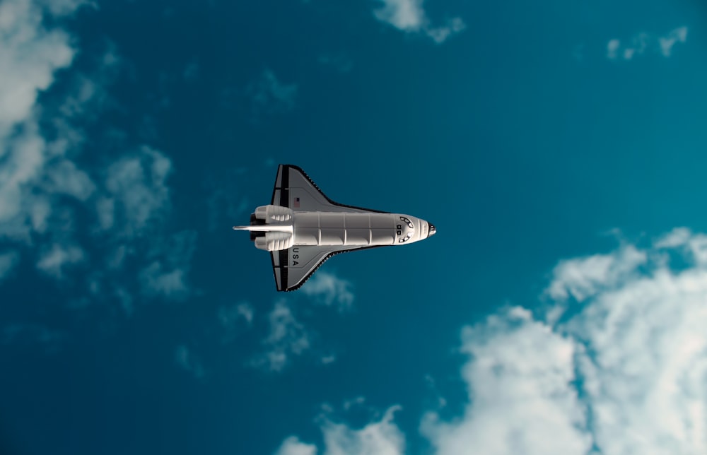 white and black jet plane in mid air under blue sky during daytime