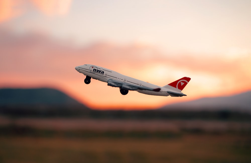 white and red passenger plane in flight