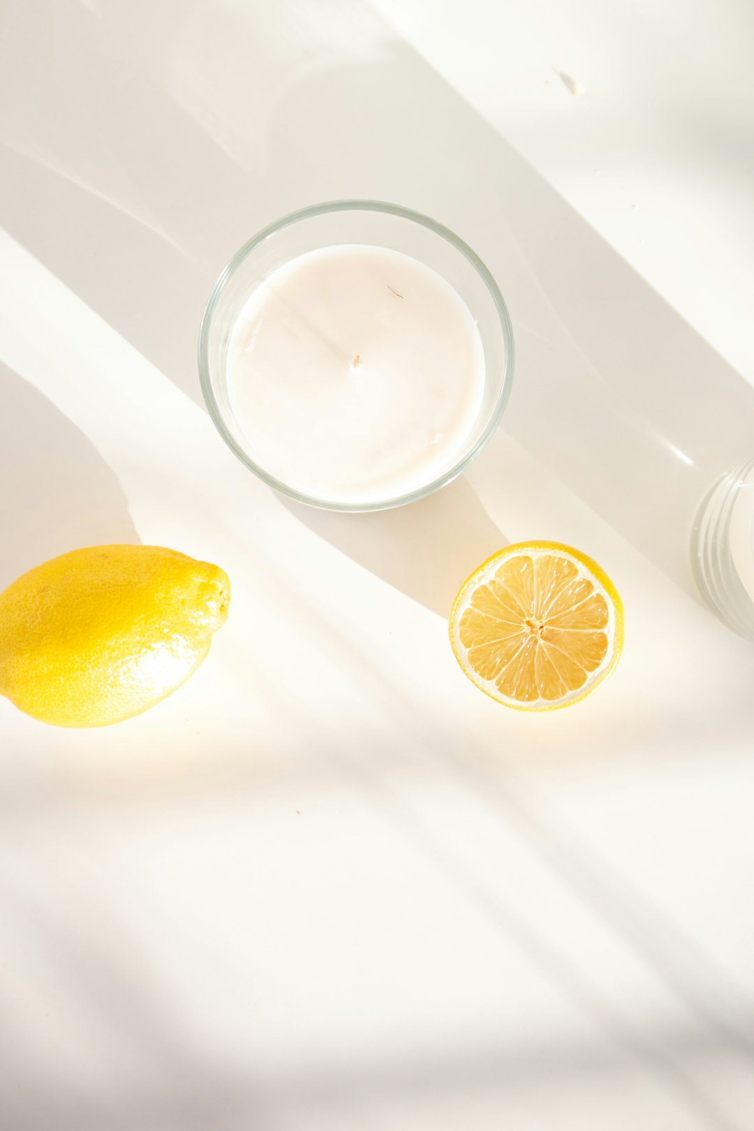 clear drinking glass with white liquid beside lemon fruit