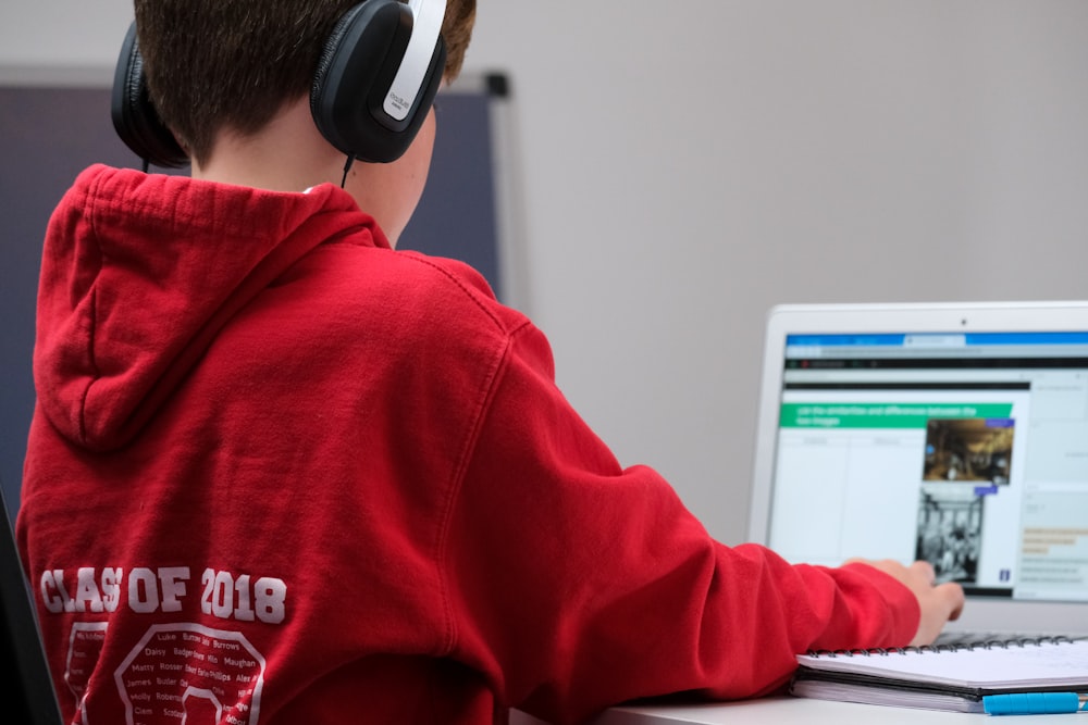 boy in red hoodie wearing black headphones