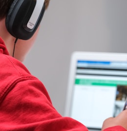 person in red shirt wearing black and gray headphones