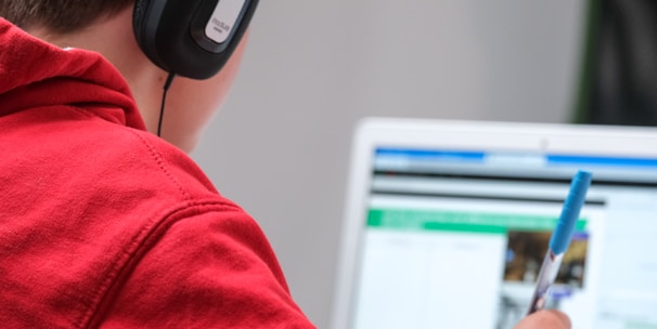 person in red shirt wearing black and gray headphones