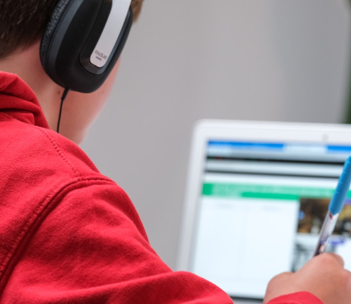 person in red shirt wearing black and gray headphones