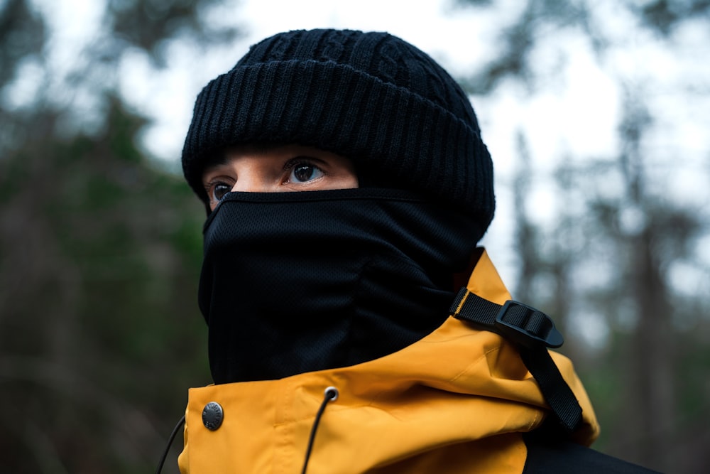person wearing black knit cap and yellow jacket