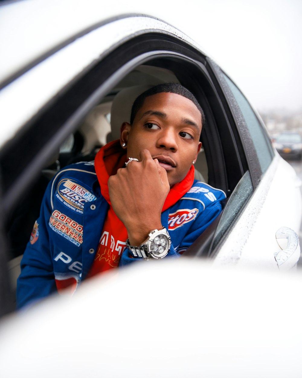 man in blue and red jacket sitting on car seat