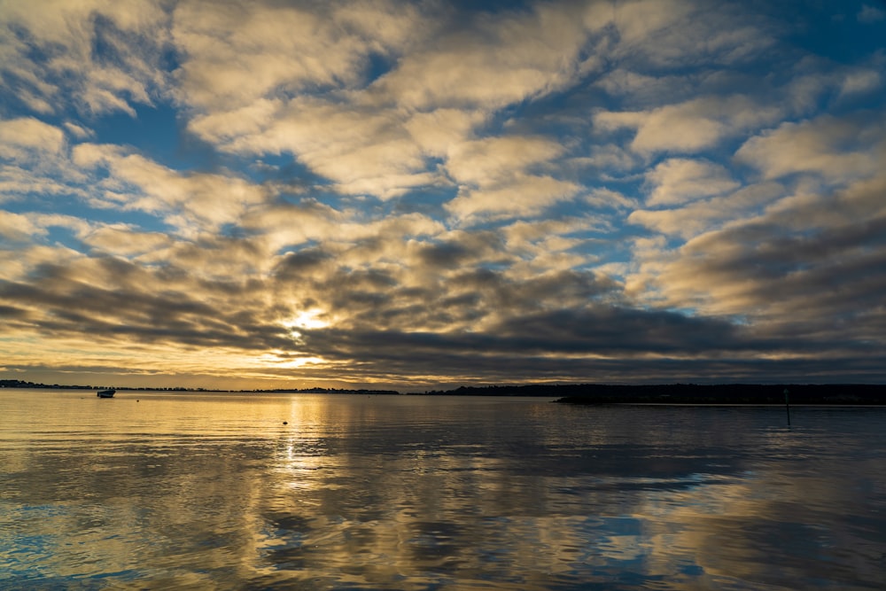 body of water under cloudy sky during daytime