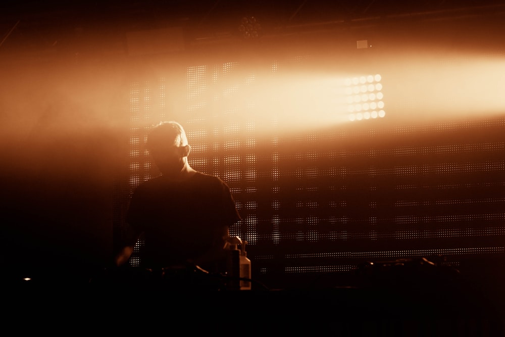 silhouette of man and woman standing in front of window with white window blinds during sunset