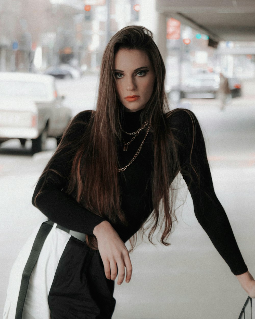 woman in black long sleeve shirt and black pants sitting on white plastic chair