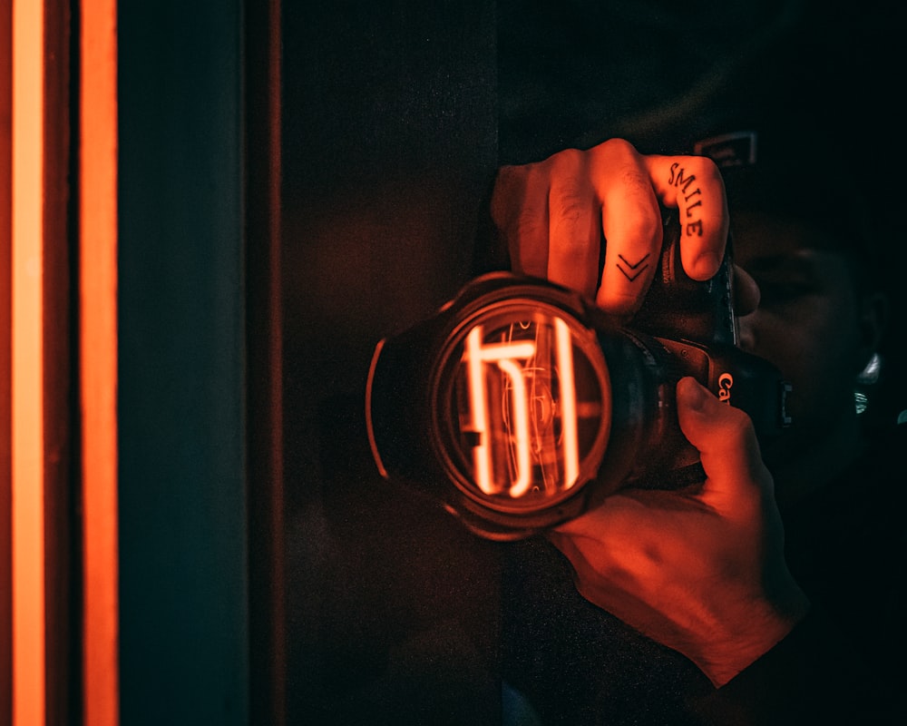 person holding black and orange led watch