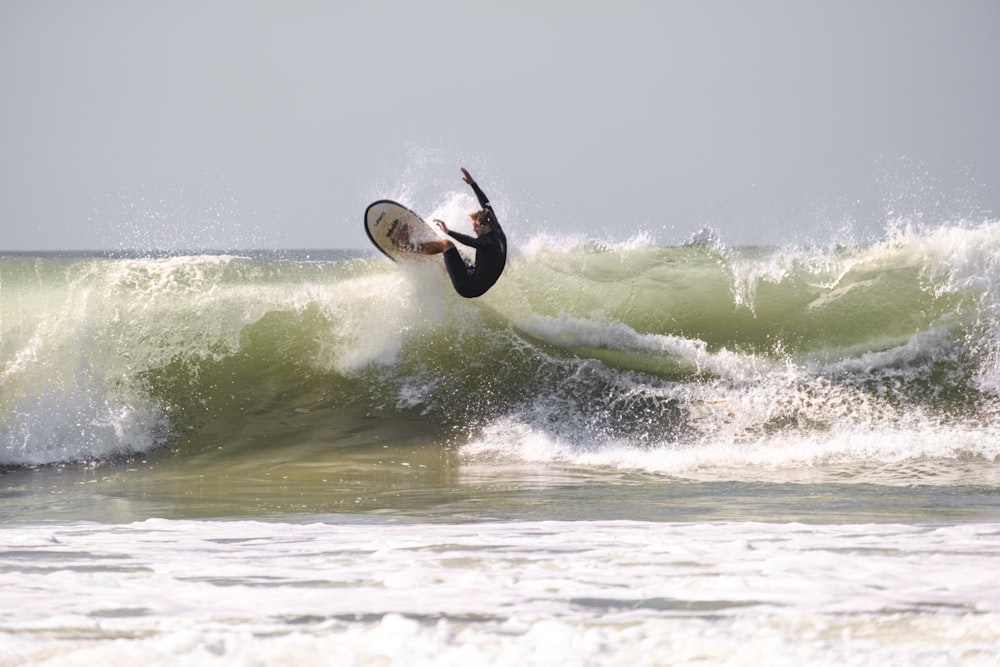 man surfing on sea waves during daytime