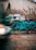 Graffiti covers a concrete wall with colorful designs and vibrant lettering, including a combination of abstract and stylized words. A blurry car with headlights on zooms past in the foreground, adding a sense of motion and urban dynamism.