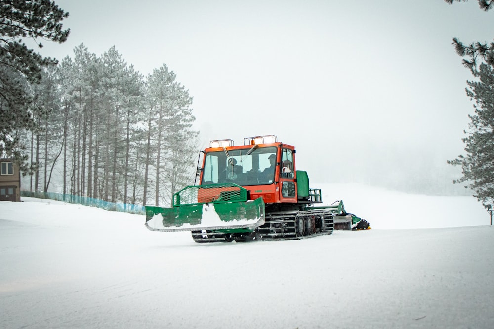 green and red heavy equipment on snow covered ground